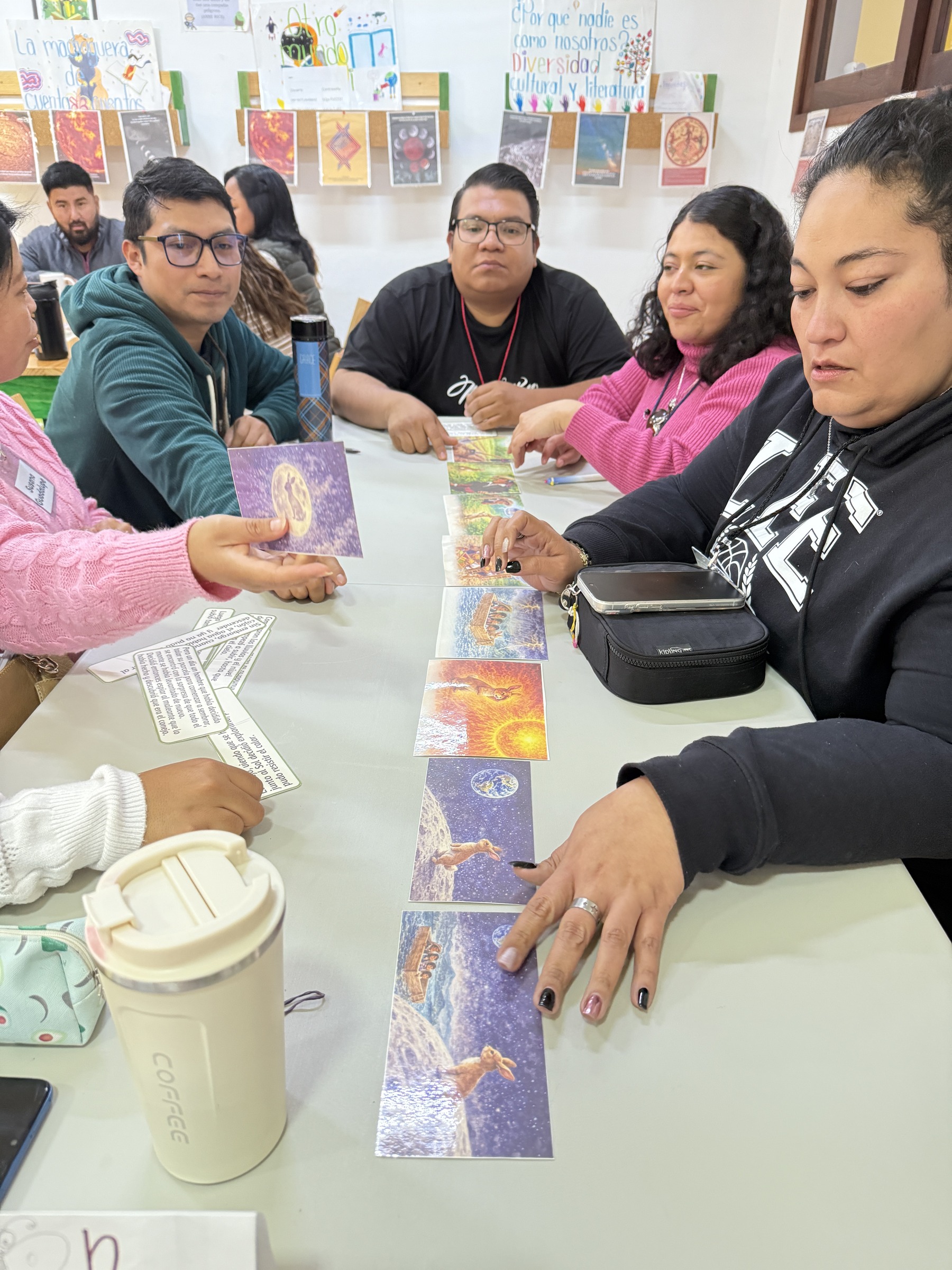 Personas revisan libros y materiales alrededor de una mesa.